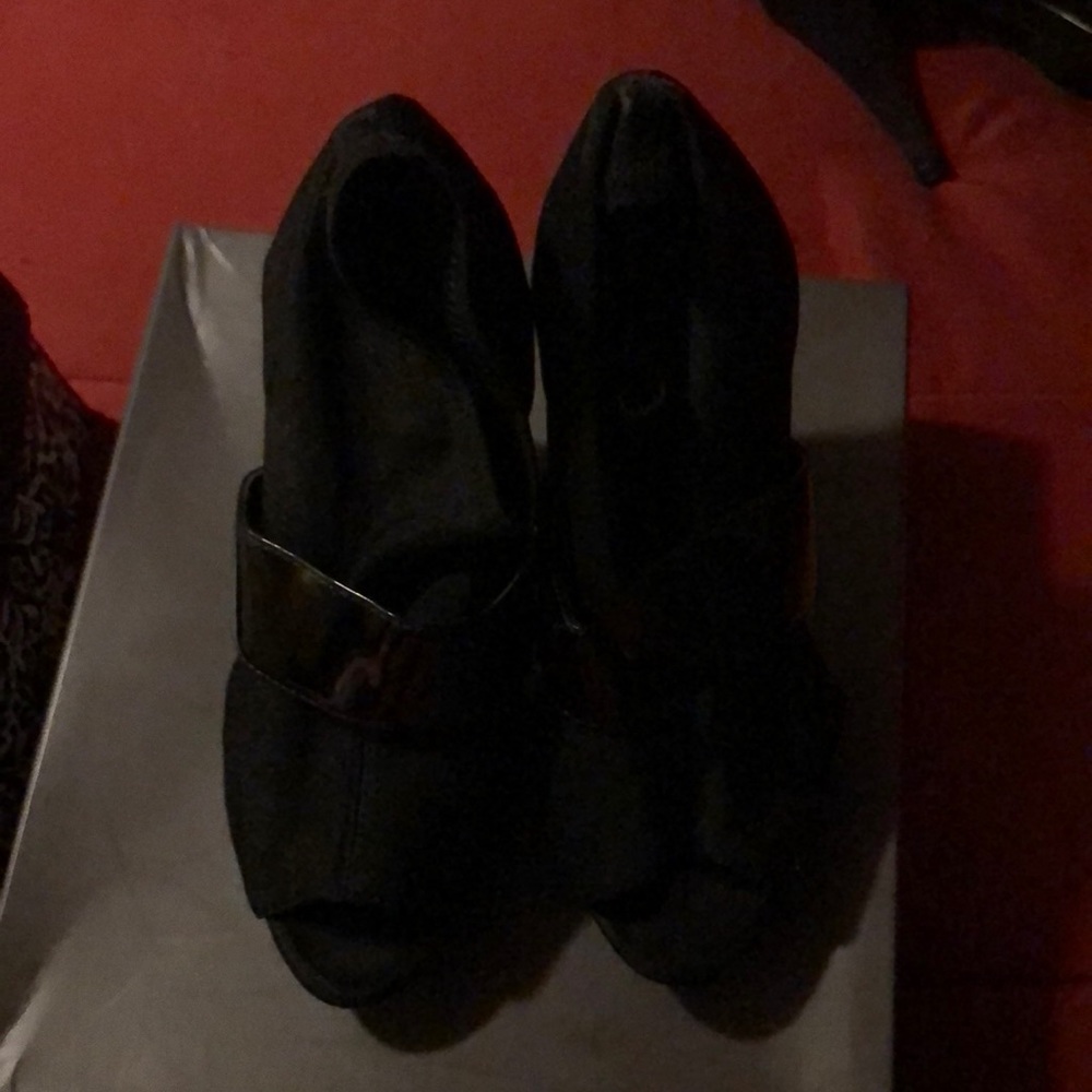 Black shoe with mesh and patent leather strap.